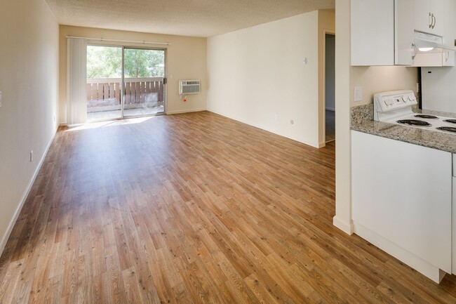 Image of a living area with wood-style plank flooring, a sliding patio door, and an air conditioner. - Casa De La Mesa