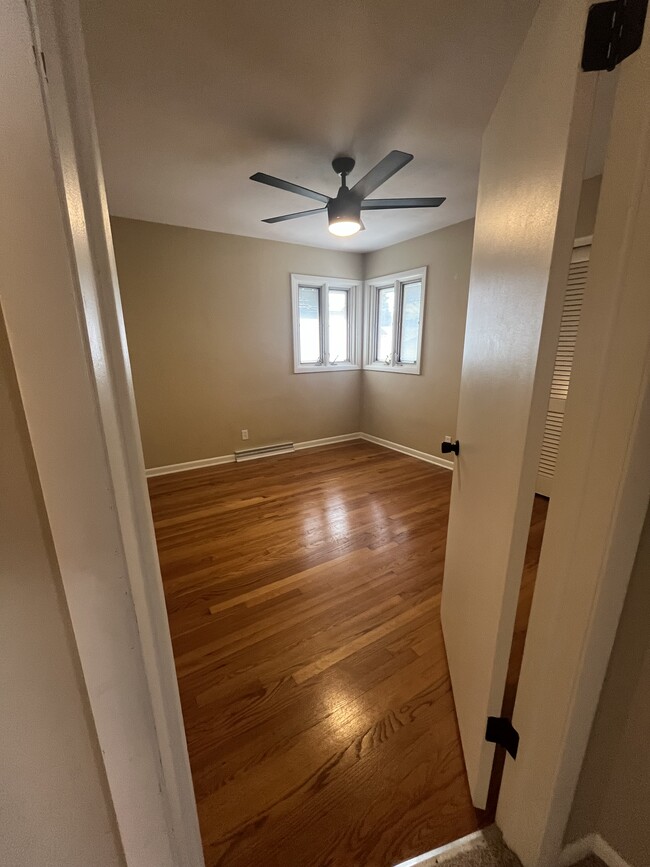 Master bedroom with ceiling fan and hardwood floor - 3007 S 95th St