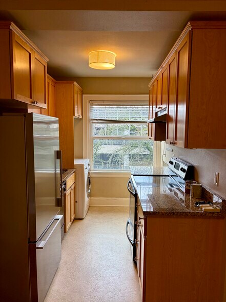 Kitchen with ample cabinet and counter top space. New counter depth refrigerator and electric stove. - 1509 NE 10th Ave