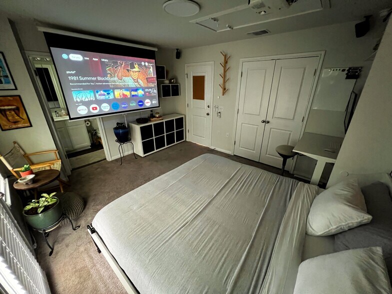 Master bedroom - King murphy bed, 80" HD projector, built-in 5.1 surround sound, and Chromecast. - 9611 Morning Iris Dr