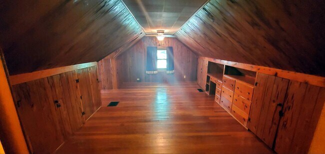 Wide-angle view highlighting ceiling height and depth of the upper-level space. - 2923 Arthur St NE