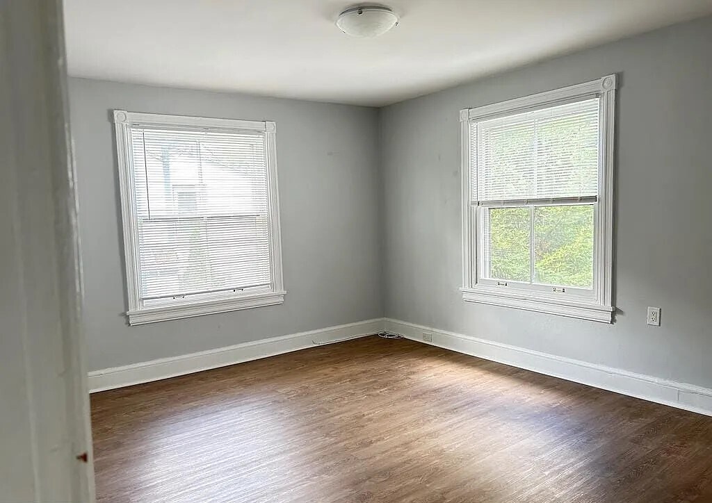Bright and spacious bedroom with large windows, abundant natural light, and updated flooring. - 453 Lancaster Ave
