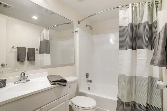 Renovated Package II bath featuring white cabinetry and countertops - eaves Tysons Corner