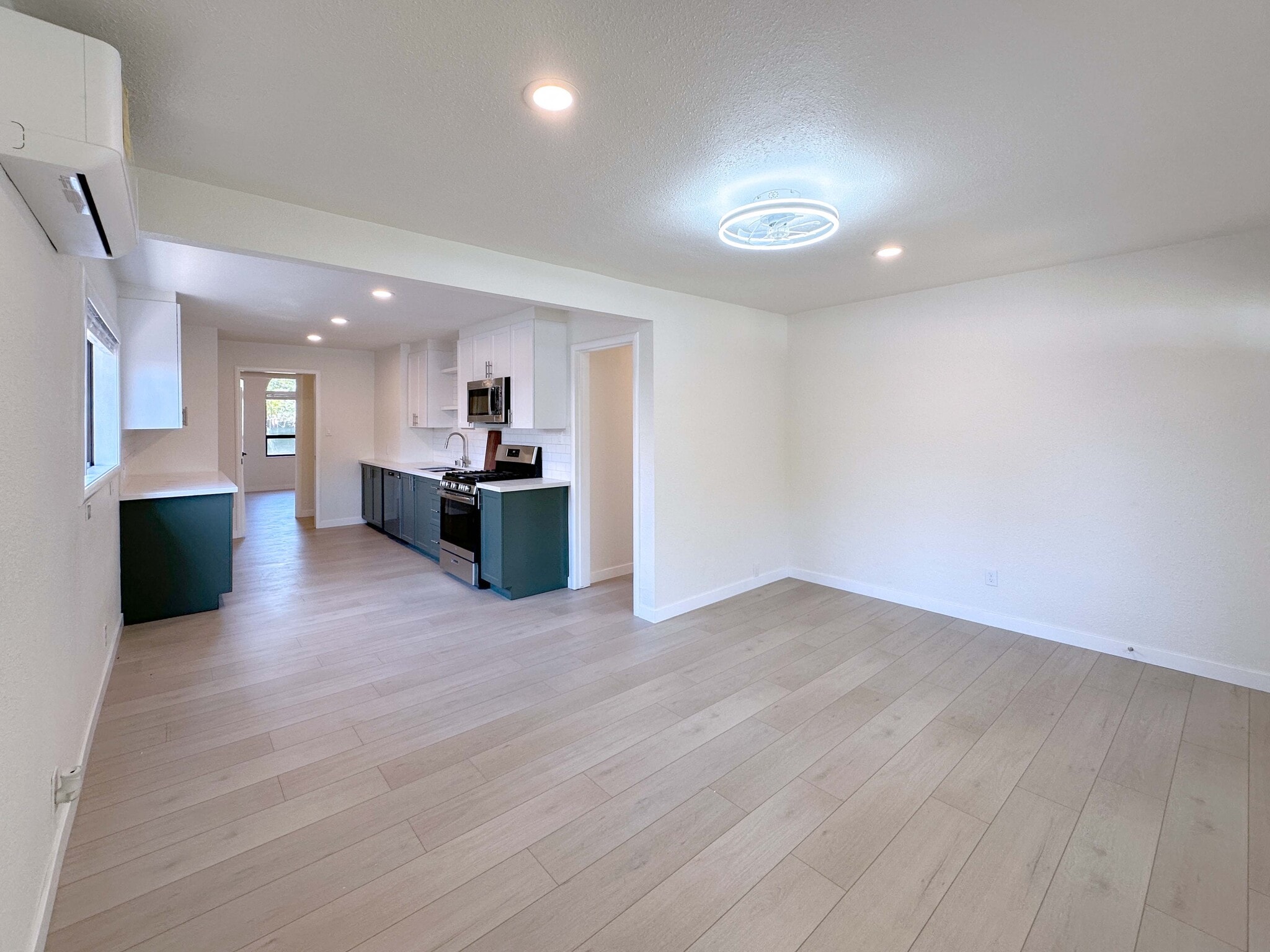 Bright and airy living room with stunning floors, energy-efficient LED lighting, ceiling fan, and mo - 4570 58th St