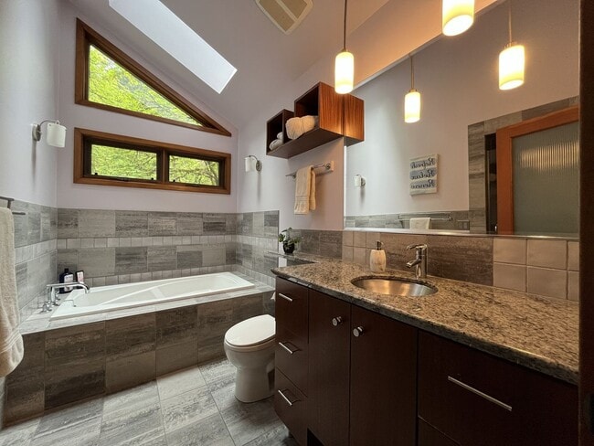 Building Photo - One-of-a-Kind Custom Home with Wall of Windows, Stone Fireplaces, Expansive Entertainment Space &...