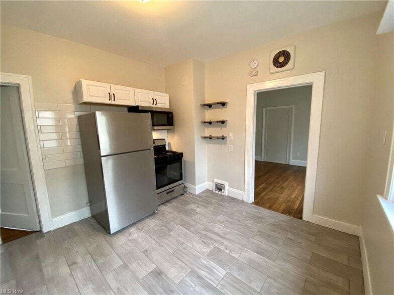 Roomy kitchen with newer appliances and updated tile - 2104 W 10th St