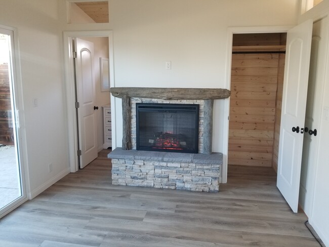 Master bedroom with wood high ceilings, ceiling fan, private courtyard, custom driftwood mantel over - 6832 Zelzah Ave