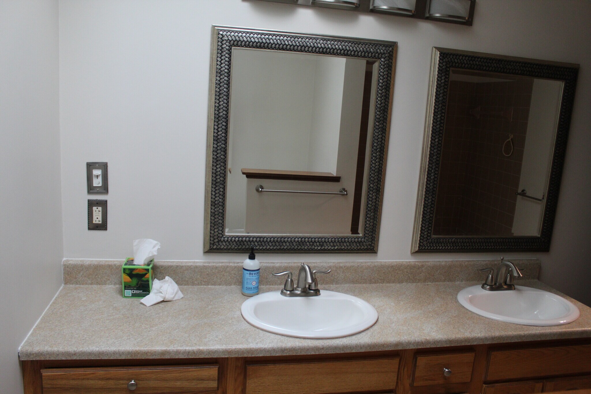 Bright bathroom featuring a dual-sink vanity with generous counter space and framed mirrors. - 6235 Sunnywood Dr