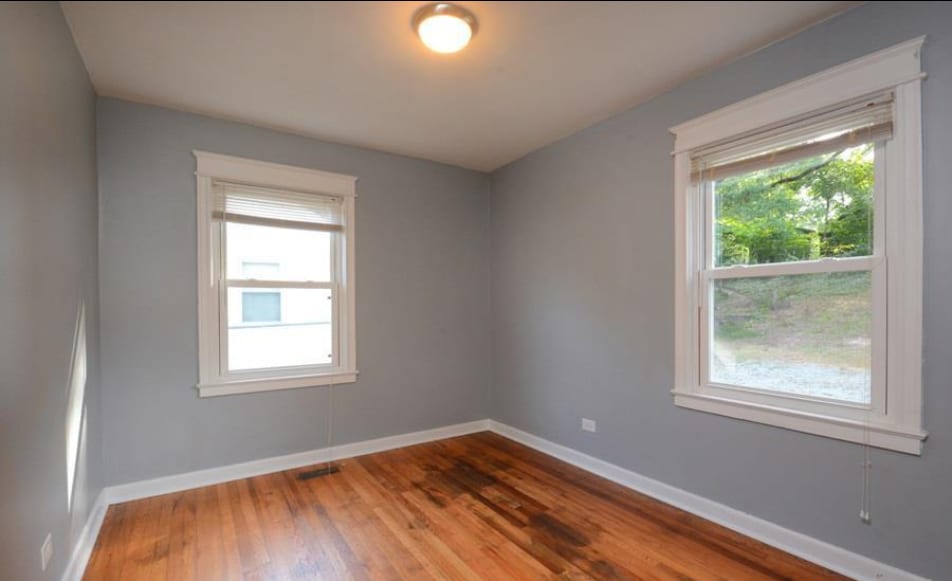 Bright bedroom with hardwood floors and neutral finishes. - 1607 Robinhood Rd