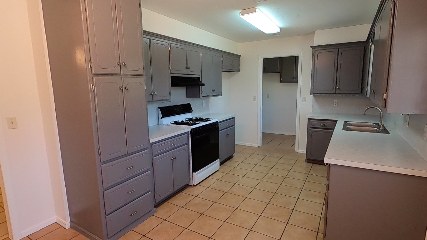 South side of kitchen - new stove vent, countertops, spot for fridge, and freshly painted cabinets with new hardware and hinges - 415 W Guthrie St