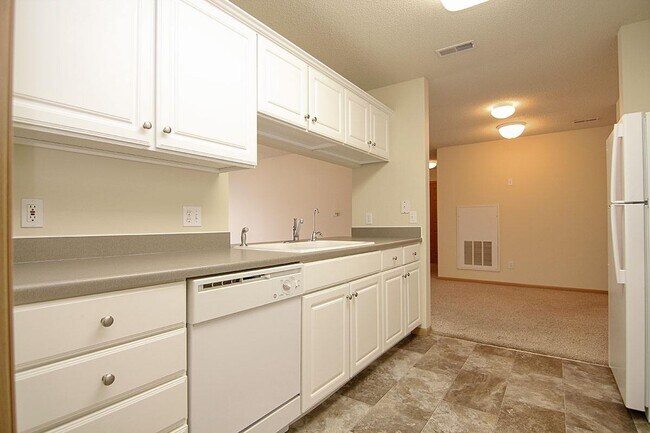 In The Gulf, enjoy an open layout where the kitchen seamlessly connects to your living space. - Pinebrook Apartments