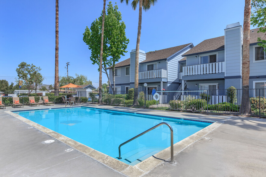 Image of the community swimming pool and welcoming lounge chairs in the background. - Camden Park