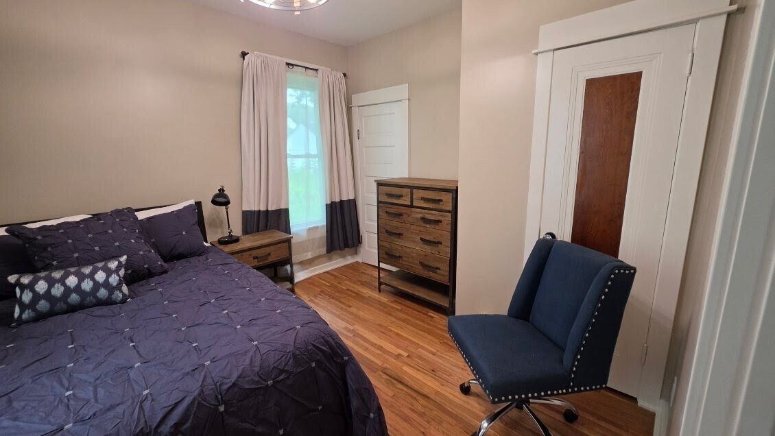 Bedroom with dresser, workspace, hardwood floors, and original woodwork. - 1901 -2301 Fillmore Street NE Minneapolis, MN 55418