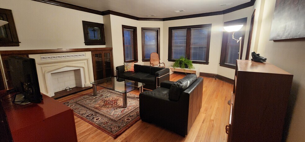 Living Room includes leather couch and armchair, rocking chair, glass coffee table, rug, large TV - 2018 Lake St