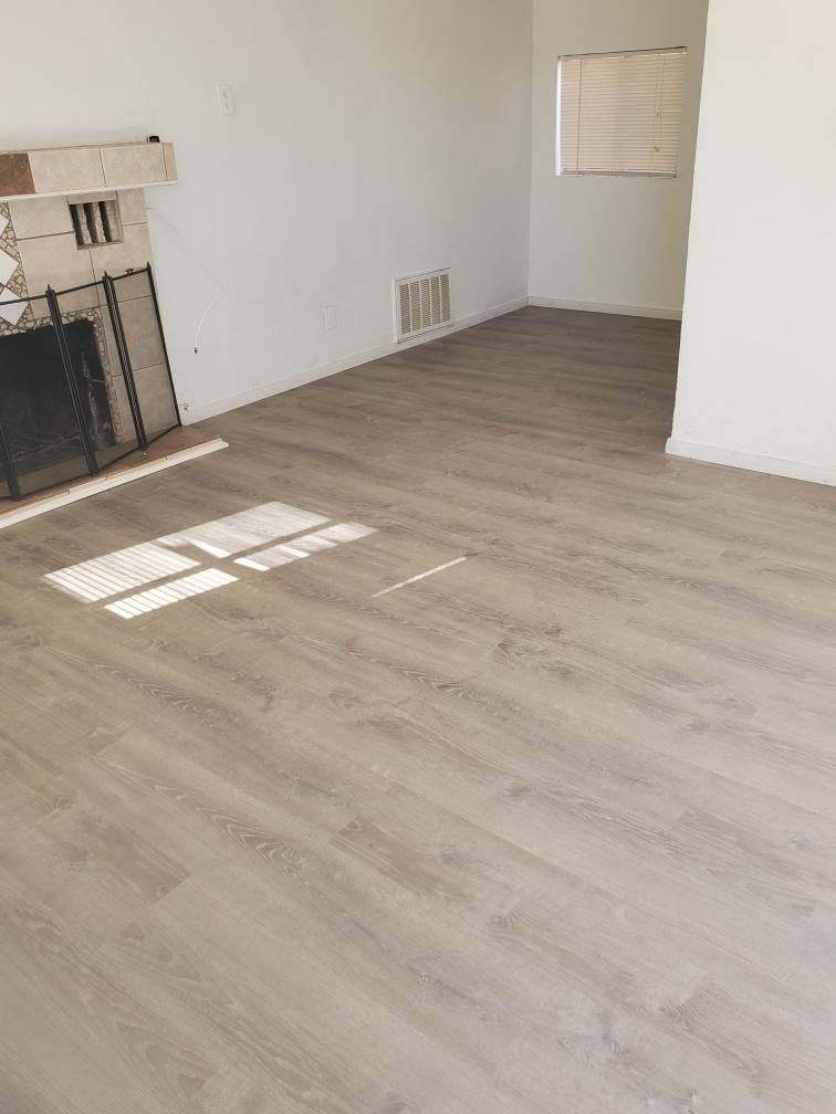 Brand new laminate plank flooring in living area & bedroom - 6432 Smoketree Ave
