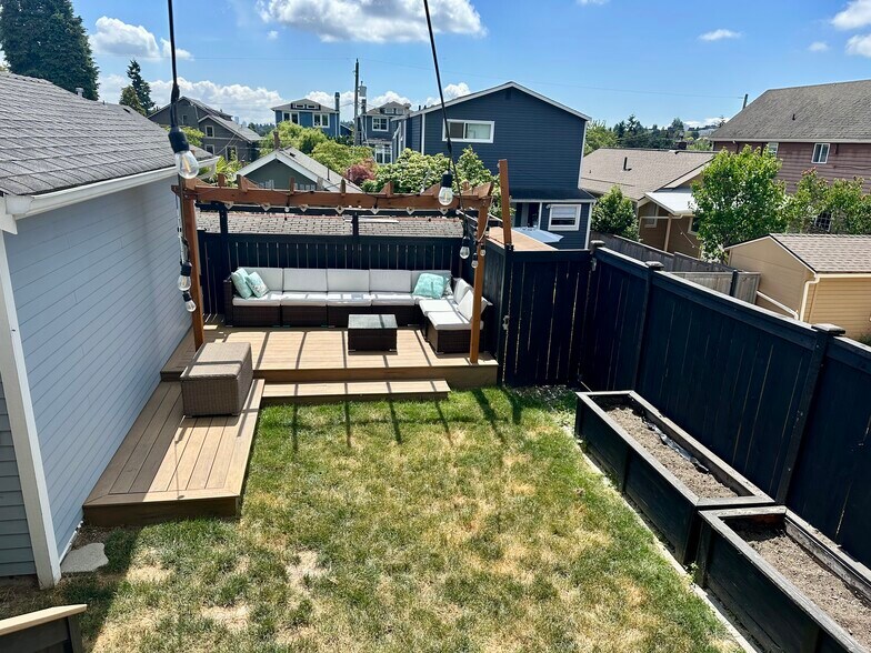 Backyard with included furniture and raised garden beds - 723 N 80th St