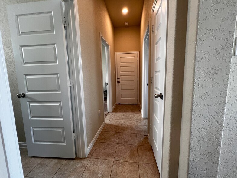 Hallway to guest bathroom, guest rooms, and garage - 9186 Devils Riv