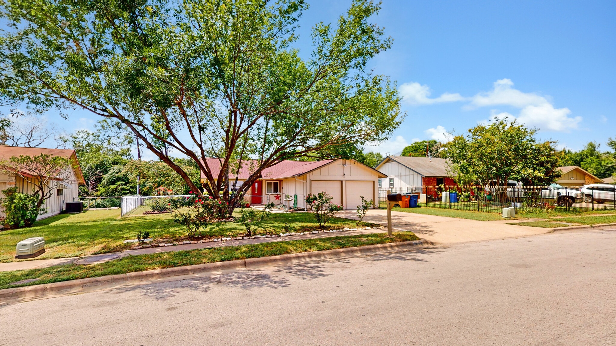 View of front of house with driveway, a residential view, an attached garage, and board and batten s - 5906 Wagon Bnd