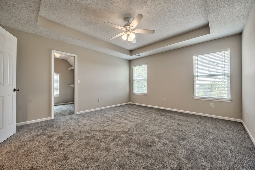 Primary bedroom with tray ceiling, ceiling fan - 22810 West 71st Terrace