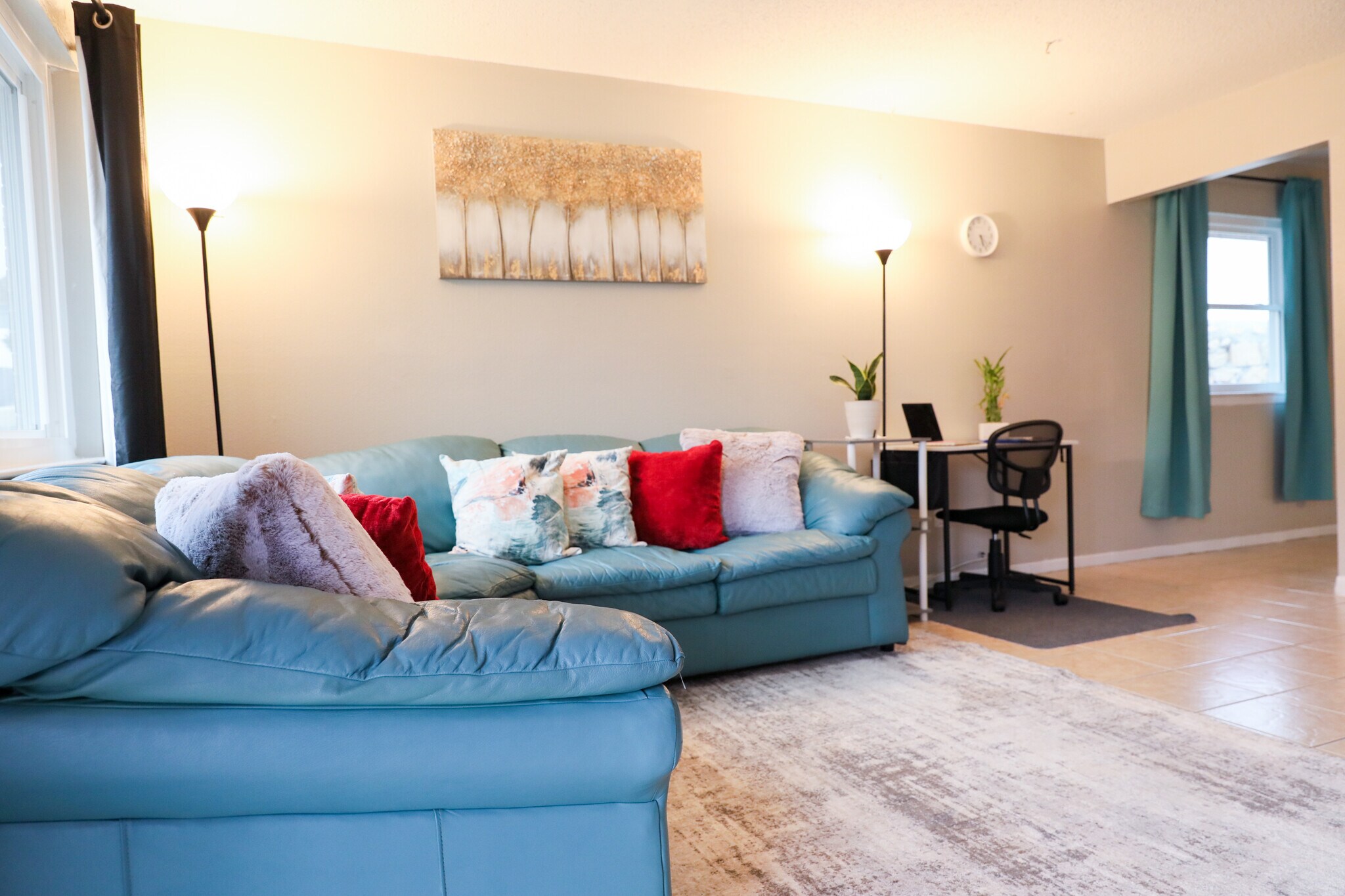 Teal couch with an assortment of pillows. Choose your fav and snuggle up. - 8612 Echo St