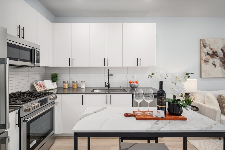 The gourmet chef’s kitchen features quartz countertops, stainless steel appliances - 8338 27th Ave NW