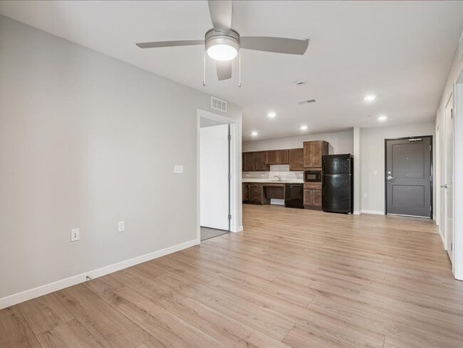 Living room with LVT flooring and ceiling fan - NEX Senior - ARRO Senior (55+) Apartments