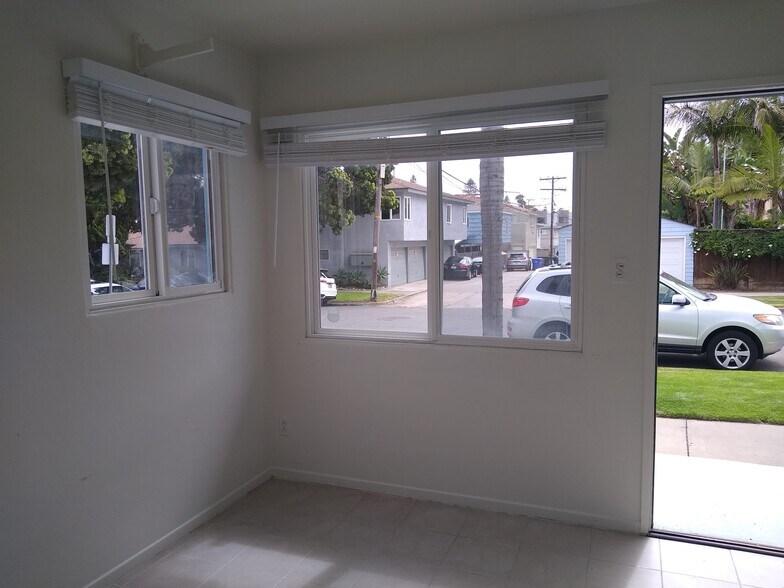 Living Room with surf rack, built-in wall heater and large windows. - 4127 Everts St
