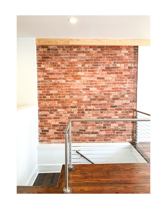 Exposed brick wall landing. - 18 W State St