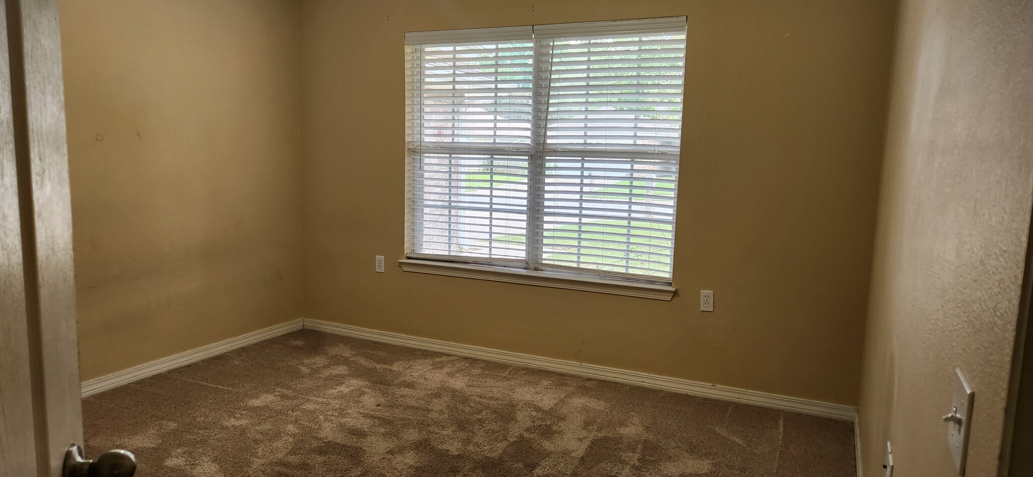 Bedroom 1 with a closet and a double window view of front yard - 2318 Tall Oak Dr
