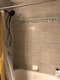 Bath/shower in this recently remodeled bathroom includes tile backsplash up to the ceiling and brand new tub. - 1809 Stark Drive