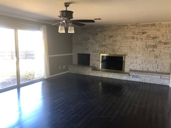 Beautiful family room with granite wall fire place and large glass walkout sliding door to fenced in yard - 302 Coronation Dr