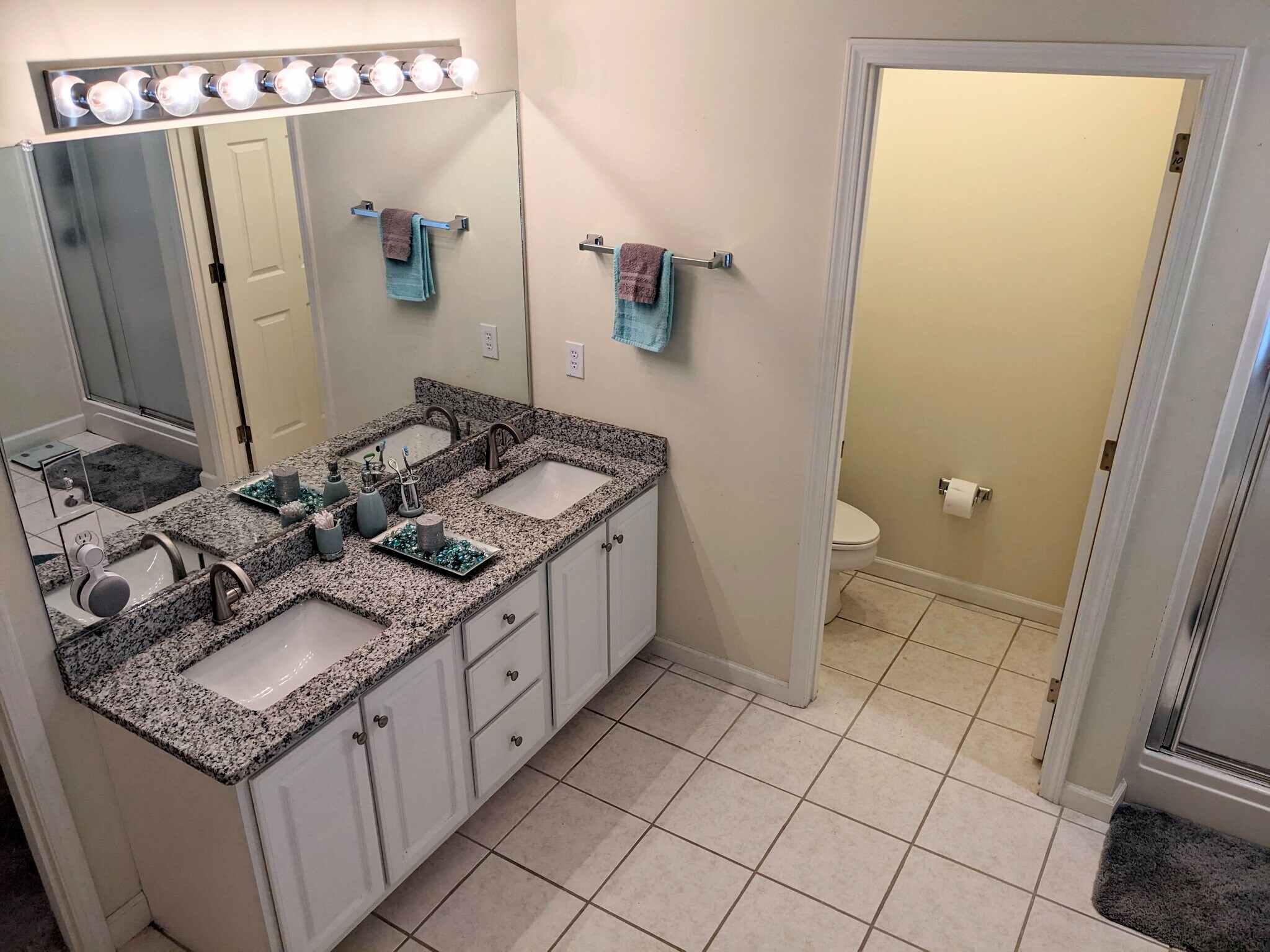 View of the vanity with granite counter, his/her sinks, and XL mirror, with the water closet attache - 424 Commerce Ave