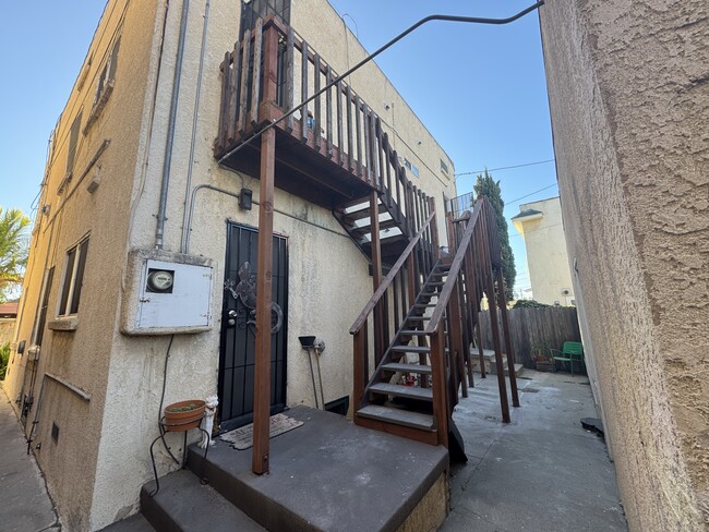 Rear exterior stairs. Left landing: primary bedroom back door. Right landing: kitchen door. - 1749 E 3rd St