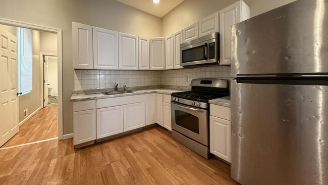 Building Photo - Charming 4BR/2BA Rowhouse with Hardwood-Style Flooring Throughout