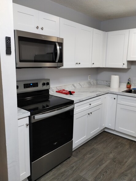 The kitchen features new cabinets and... - 441 Harding Pl