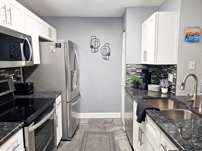 Our kitchen features stainless steel appliances including a dishwasher - 8923 Manor Loop