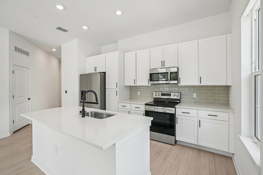 Open Kitchen with Stainless Steel Appliances - Evelyn City Lofts