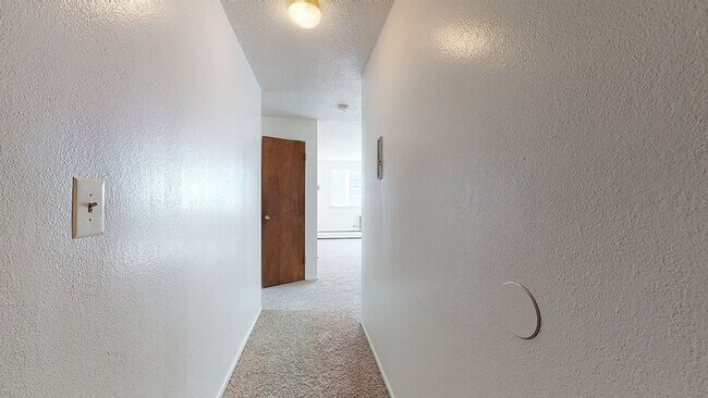 Explore the welcoming entryway of this airy apartment, promising comfort and style. - Harmony Apartments