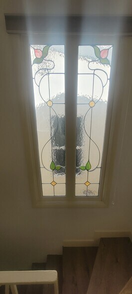 Stained glass window at too if stairs leading to 2 bedrooms and full bath - 8934 Wonderland Ave