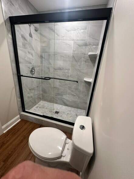 Walk-in shower featuring floor-to-ceiling tile, a frameless sliding door - 55 Providence Ave