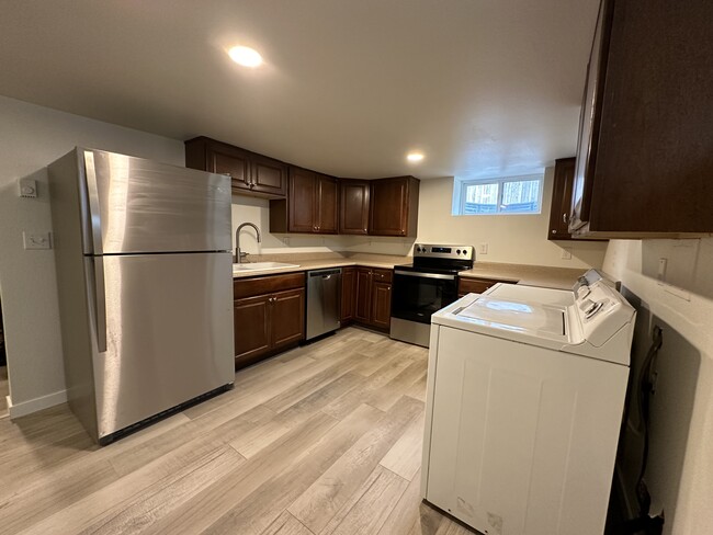 Kitchen with washer/dryer and new stainless steel appliances - 1137 E Platte Ave