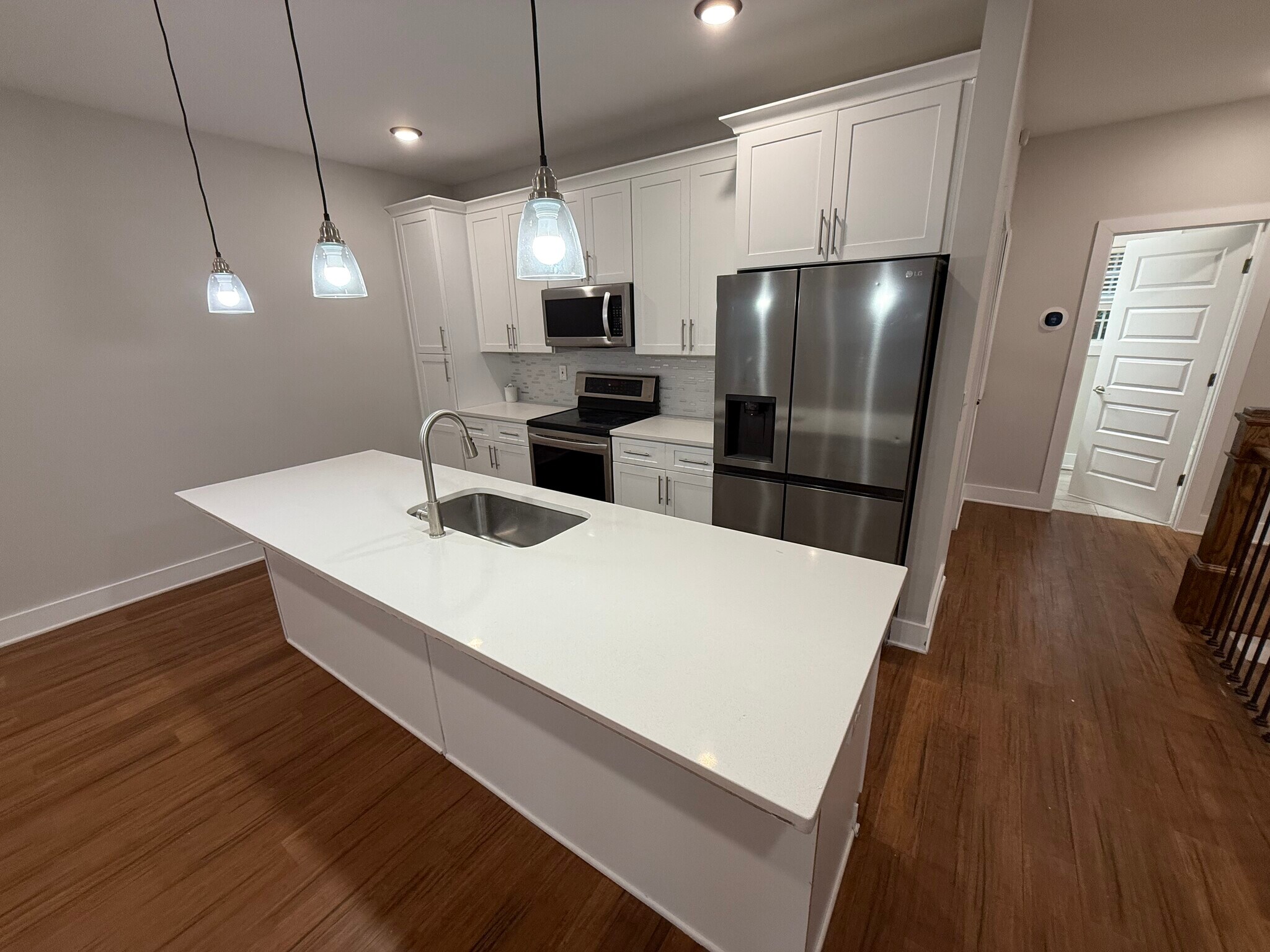 Second-Floor Kitchen: Modern kitchen with stainless steel appliances, white cabinets & large island. - 421 Elysian Fields Rd