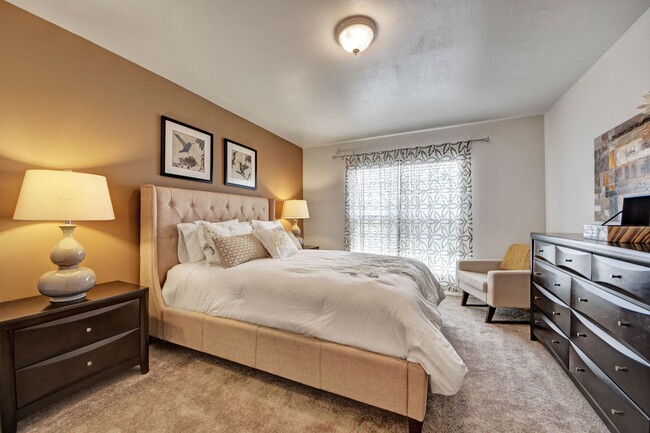 A bedroom with overhead lighting and a sliding glass door out to the patio - High Plains