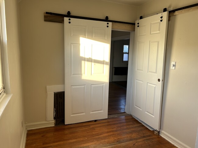 Smaller room with barn doors and hardwood floors - 724 Huntington Rd