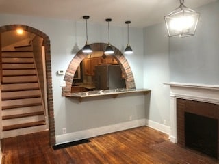 Living Room with non-functional fireplace, archway to kitchen with a breakfast bar. Just add stools. Brick accents. - 116 Bowmar St