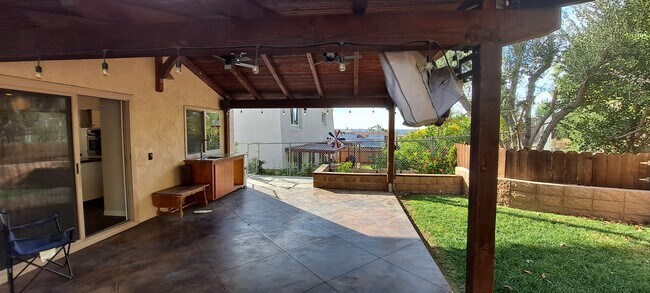 outdoor patio includes sink, granite counter, fans and a TV - 5966 Quiet Slope Dr