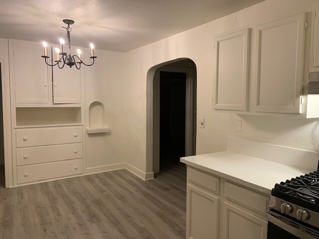 View from the kitchen of the arched doorway into the living room. - 24606 University Ave