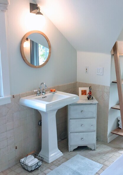 Master Bathroom vanity (open and perpendicular to stairs and bed), Toilette and shower around to the right. - 54 NE Graham St