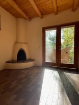 Primary bedroom with kiva fireplace and heated brick floors - 1470B Bishops Lodge Rd