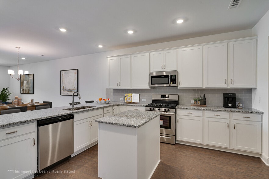 Kitchen looking into the LR and over the large breakfast bar. Staged Photo - 415 Alter Ter